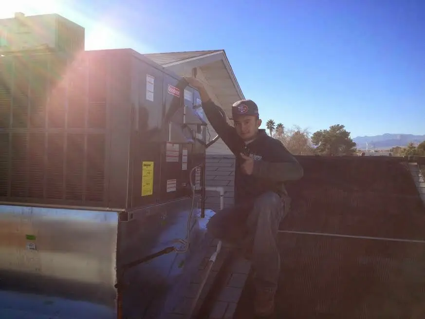 HVAC technician performing Boiler Repair on a rooftop unit in Prattville